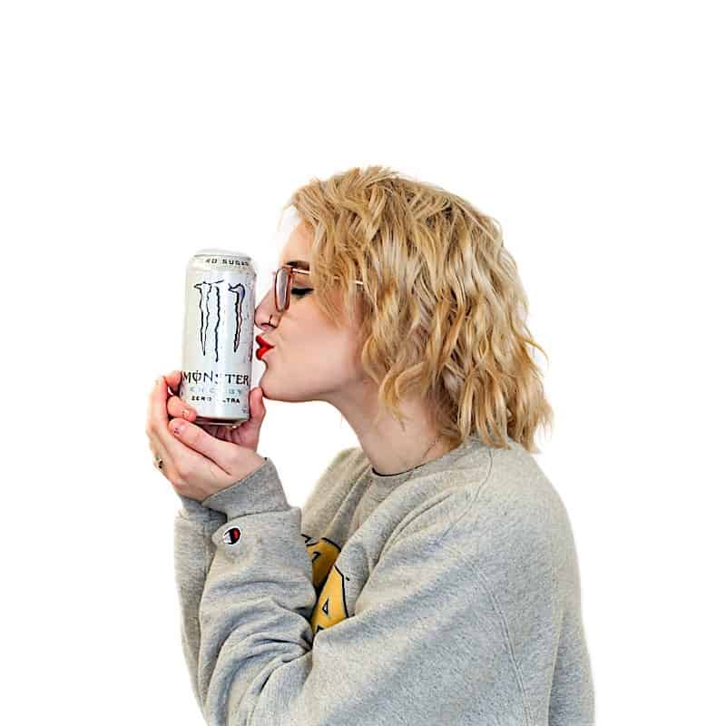Woman kissing a Monster Energy drink can at a hair salon.